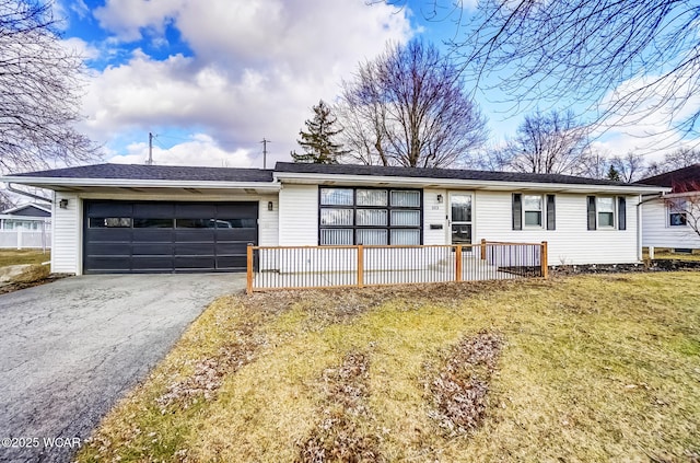 single story home with aphalt driveway, a front yard, and an attached garage