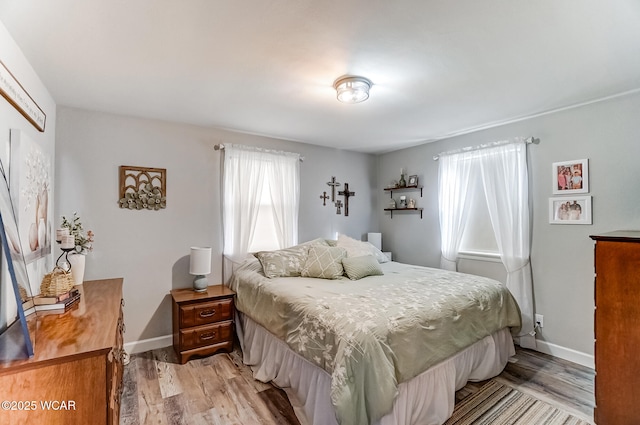 bedroom with baseboards and light wood finished floors