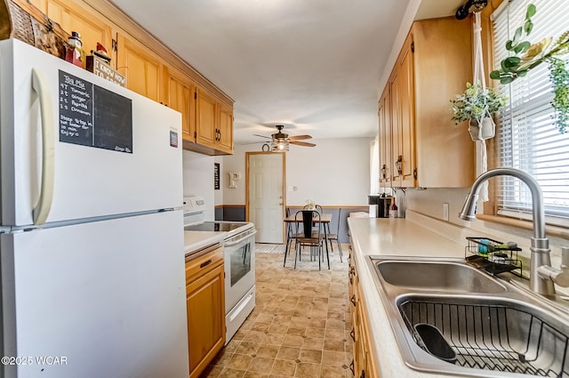 kitchen with white appliances, ceiling fan, light countertops, and a sink