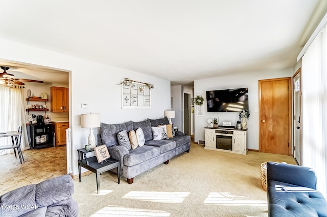 living room with light carpet, ceiling fan, and baseboards