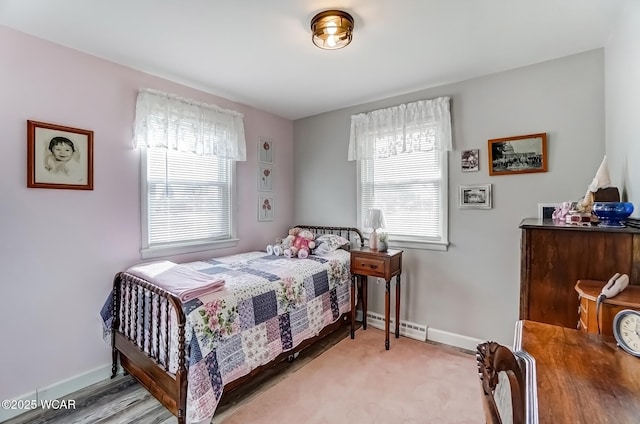 carpeted bedroom featuring multiple windows, baseboards, and baseboard heating