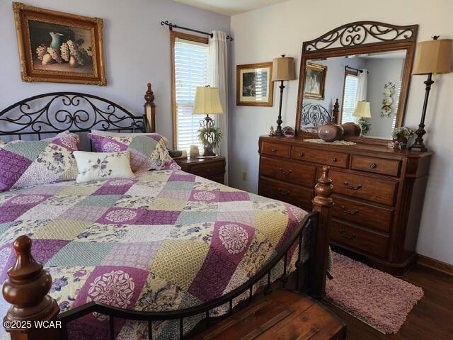 bedroom with baseboards and wood finished floors