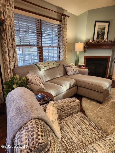 living area with a glass covered fireplace and wood finished floors