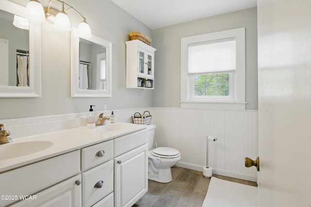 800 S Tyler St, Van Wert, OH 45891 - full bathroom featuring wainscoting, wood finished floors, toilet, and double vanity