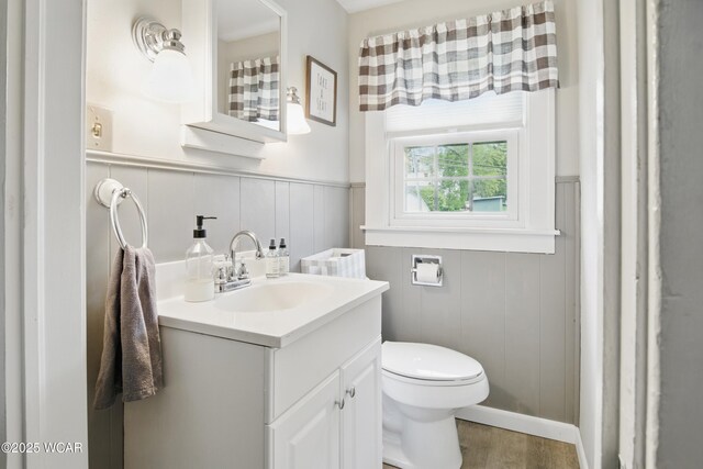800 S Tyler St, Van Wert, OH 45891 - bathroom featuring vanity, toilet, wood finished floors, and wainscoting