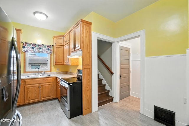 210 N Pierce St, Delphos, OH 45833 - kitchen with stainless steel electric range oven, freestanding refrigerator, under cabinet range hood, light countertops, and light wood-style floors