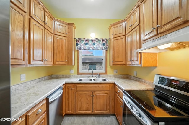 210 N Pierce St, Delphos, OH 45833 - kitchen with stainless steel appliances, under cabinet range hood, light countertops, and brown cabinetry