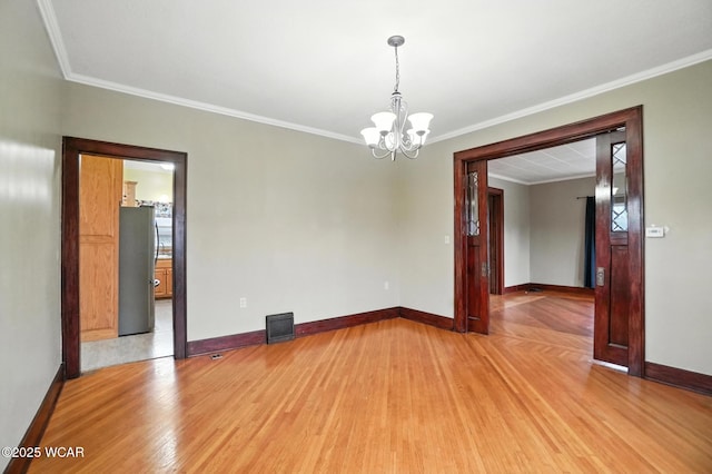 210 N Pierce St, Delphos, OH 45833 - unfurnished room with light wood-style floors, a chandelier, and ornamental molding