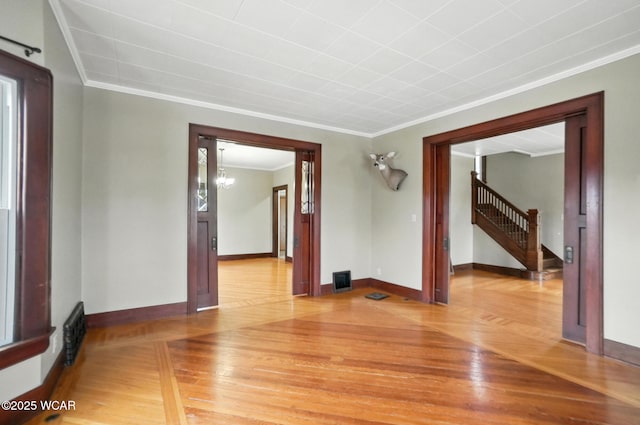 210 N Pierce St, Delphos, OH 45833 - unfurnished room with ornamental molding, light wood-type flooring, a chandelier, and stairs