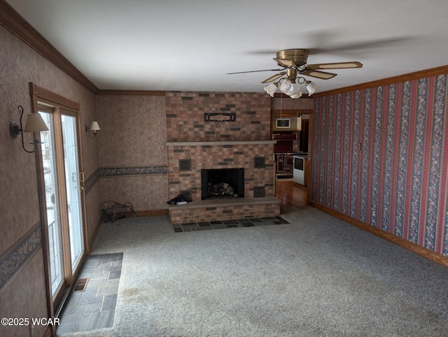 unfurnished living room with carpet, ornamental molding, a brick fireplace, and wallpapered walls