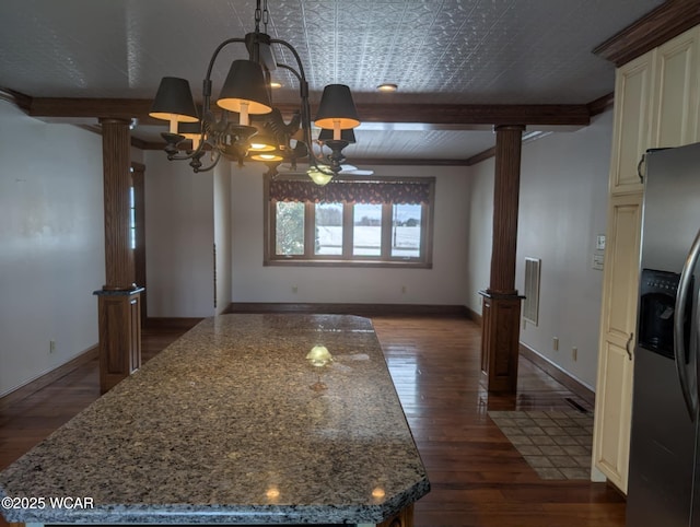 interior space with dark stone countertops, stainless steel refrigerator with ice dispenser, and ornate columns