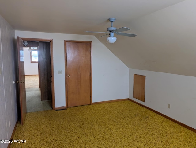 additional living space featuring carpet, vaulted ceiling, baseboards, and ceiling fan