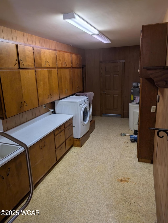 laundry area with cabinet space, wood walls, and independent washer and dryer