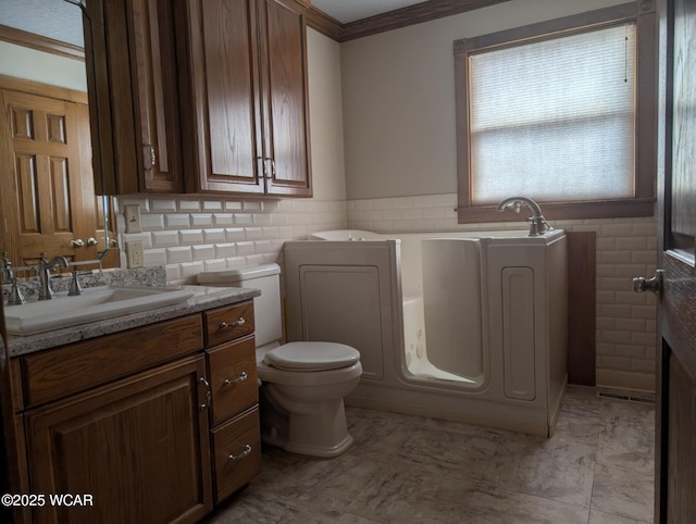 full bath with a bathtub, tile walls, toilet, ornamental molding, and vanity