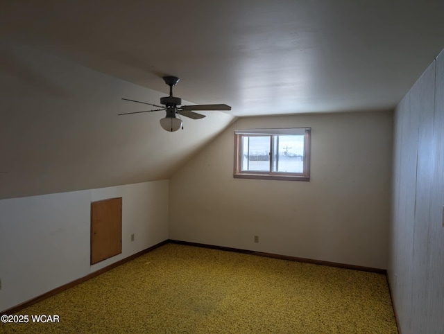 additional living space featuring baseboards, vaulted ceiling, and a ceiling fan