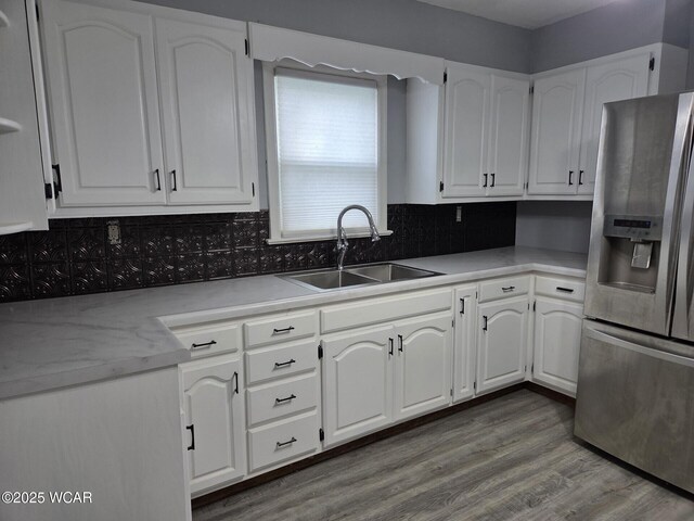 220 W N St, Elida, OH 45807 - kitchen with stainless steel refrigerator with ice dispenser, white cabinetry, decorative backsplash, and light countertops