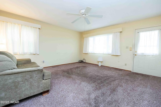 carpeted living room featuring plenty of natural light and ceiling fan