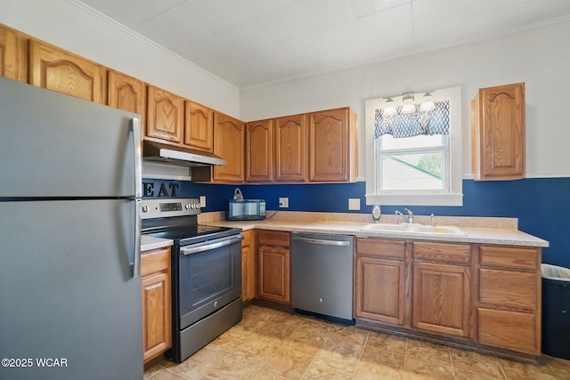 kitchen with a sink, brown cabinets, appliances with stainless steel finishes, light countertops, and under cabinet range hood