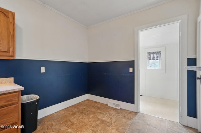 interior space with visible vents, baseboards, and ornamental molding