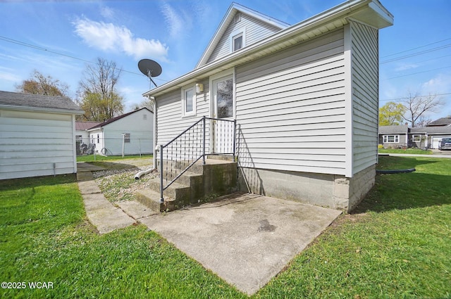 property entrance with a lawn