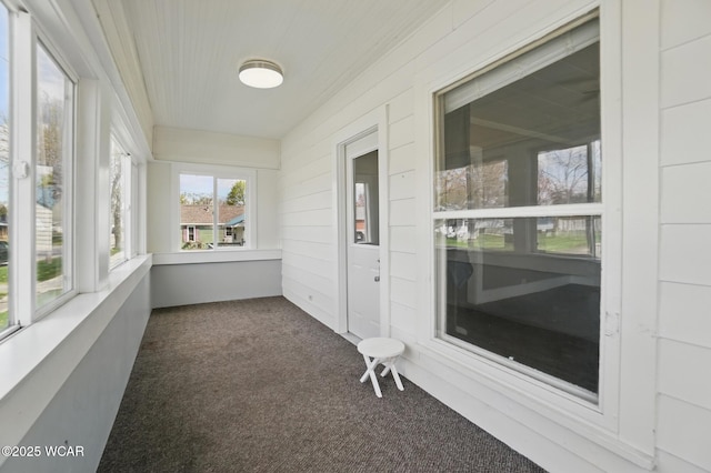 unfurnished sunroom featuring carpet flooring