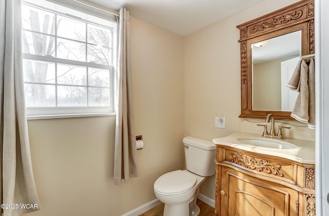 bathroom featuring baseboards, toilet, and vanity