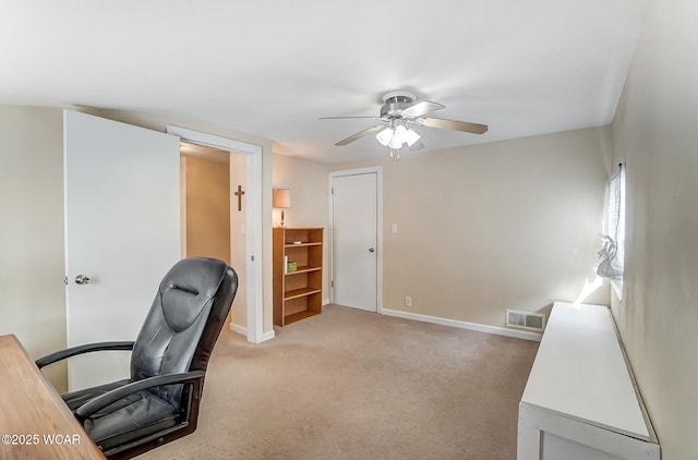 office area featuring visible vents, baseboards, light colored carpet, and a ceiling fan