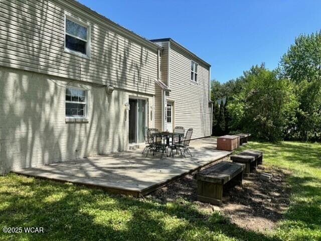 back of property with a hot tub, a wooden deck, a lawn, and outdoor dining area