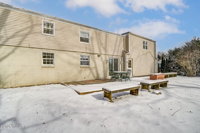 view of snow covered back of property