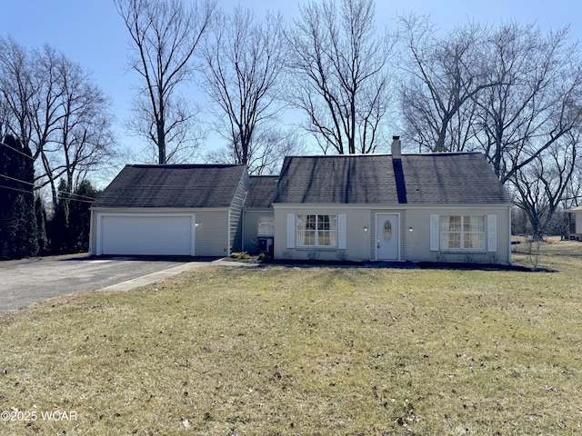 view of front of property featuring a garage, a chimney, and a front lawn