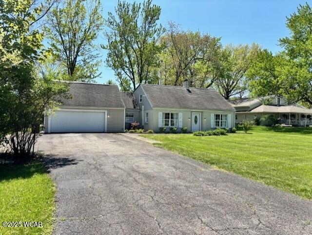view of front of house with asphalt driveway, a front yard, and a garage