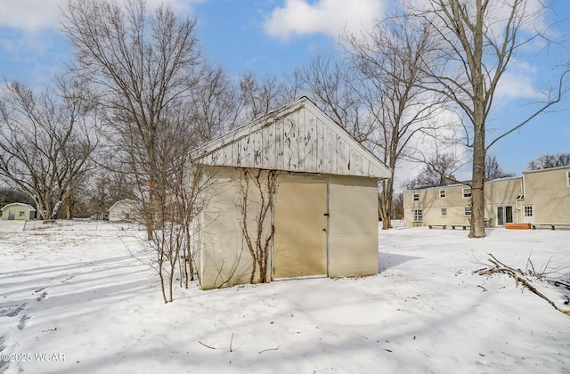 snow covered structure featuring an outbuilding