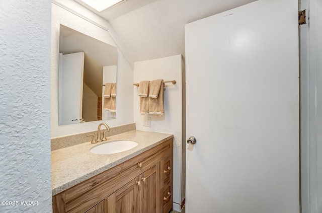 bathroom with vanity and vaulted ceiling