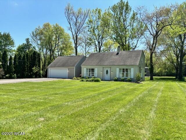 view of front of property with asphalt driveway, a garage, and a front lawn