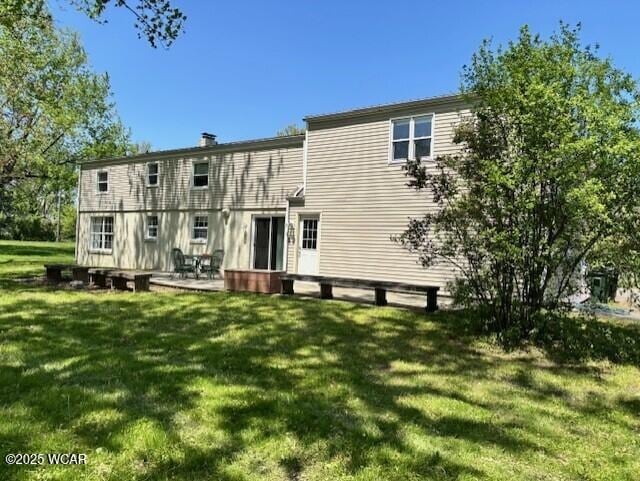 rear view of house featuring a lawn