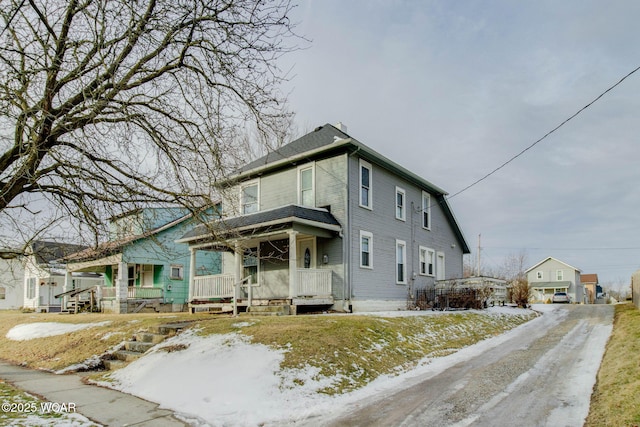 american foursquare style home featuring covered porch