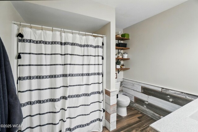 2357 London Dr, Lima, OH 45805 - full bath featuring toilet, wood finished floors, wainscoting, vanity, and a shower with shower curtain