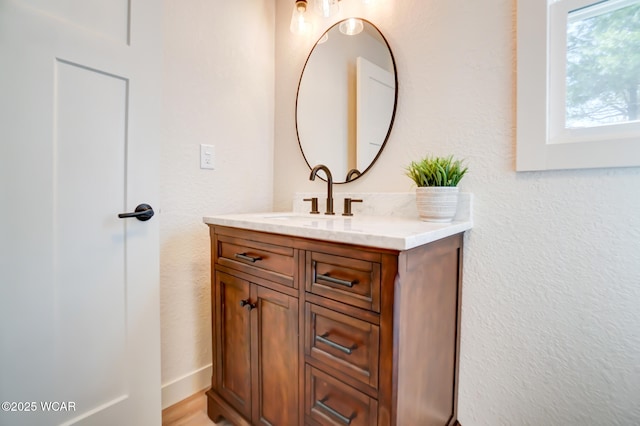 bathroom featuring a textured wall and vanity