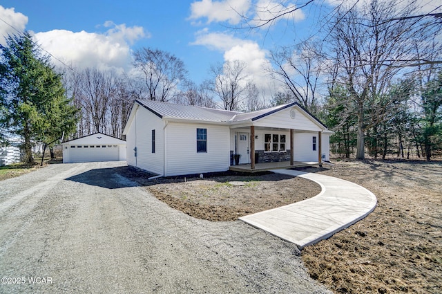 ranch-style house with covered porch, a standing seam roof, an outdoor structure, metal roof, and a garage