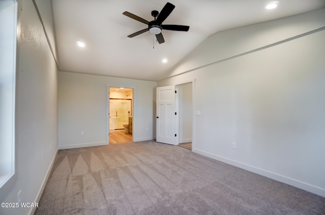 unfurnished bedroom with light carpet, lofted ceiling, ensuite bath, baseboards, and recessed lighting