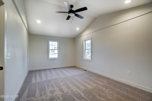 empty room with carpet flooring, a healthy amount of sunlight, lofted ceiling, and ceiling fan