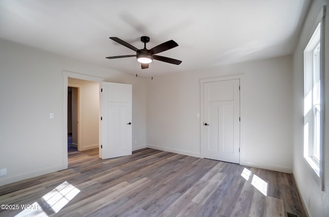unfurnished bedroom with visible vents, baseboards, ceiling fan, and wood finished floors