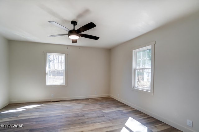 unfurnished room featuring a ceiling fan, baseboards, and wood finished floors