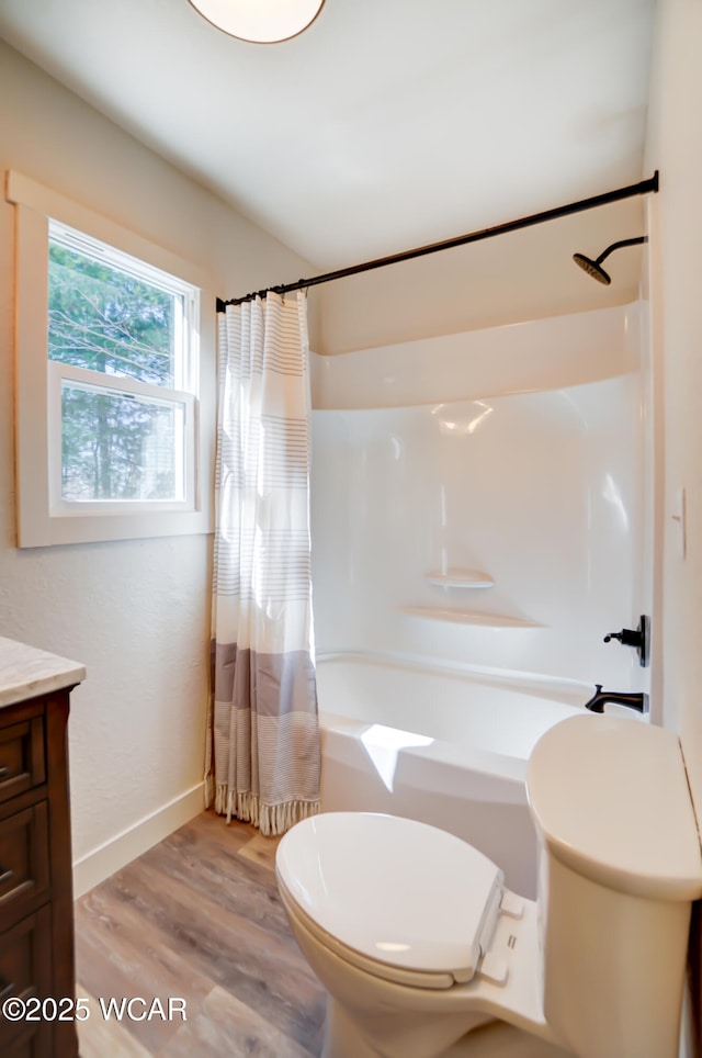 full bath featuring baseboards, toilet, wood finished floors, vanity, and shower / tub combo with curtain