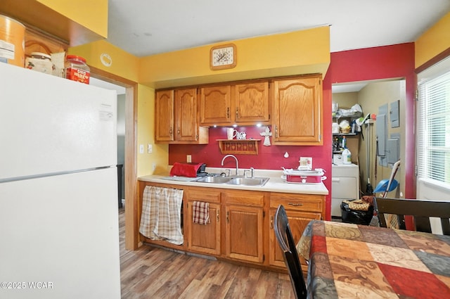 5176 Norfolk St, Lima, OH 45806 - kitchen with freestanding refrigerator, light countertops, washer / clothes dryer, light wood-style flooring, and brown cabinetry