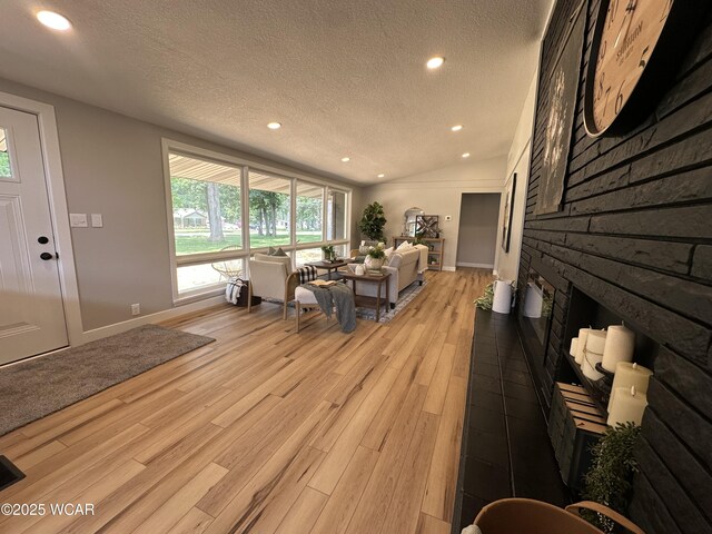 1271 Forest Dr, Lima, OH 45805 - living area with a textured ceiling, light wood-style flooring, recessed lighting, and a large fireplace