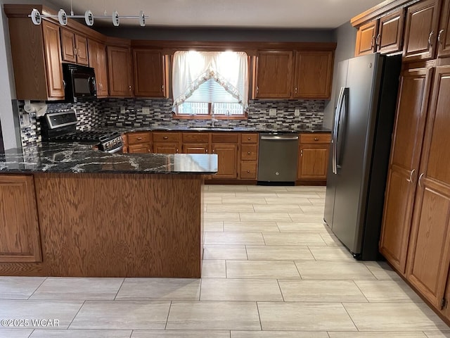 1421 Krendl Dr, Van Wert, OH 45891 - kitchen with stainless steel appliances, a sink, backsplash, a peninsula, and dark stone countertops