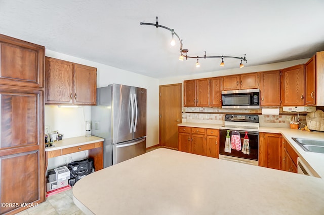 kitchen with backsplash, light countertops, a sink, and stainless steel appliances