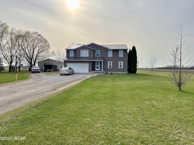 traditional-style home with a front yard, driveway, an attached garage, and metal roof