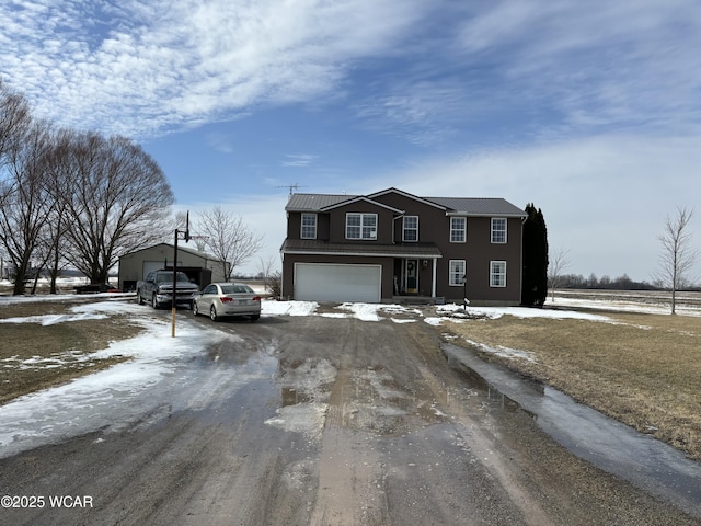 traditional home with dirt driveway, metal roof, and an attached garage